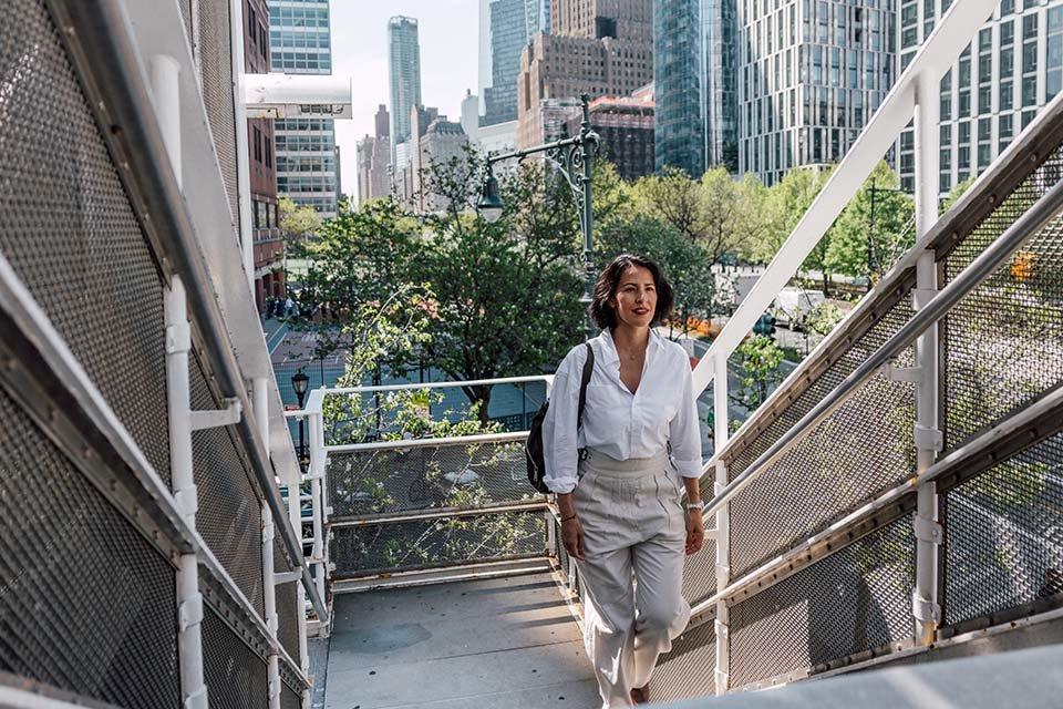 Business woman walking up stairs outside in a city.